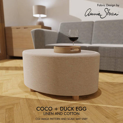 Oval coffee table footstool featuring upholstery from Annie Sloan's linen union fabric range Coco and Duck Egg, radiating a sense of understated elegance and refinement.